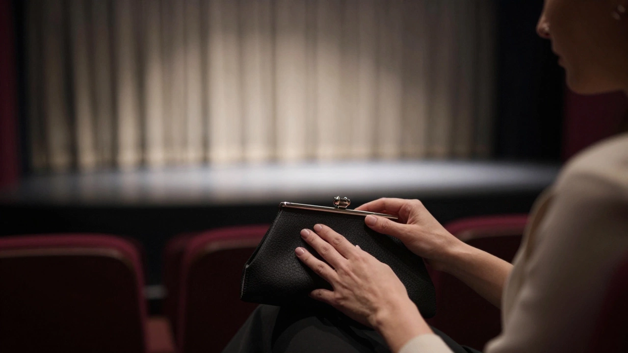 Close-up of hands placing clutch in theater, stage light rising behind.